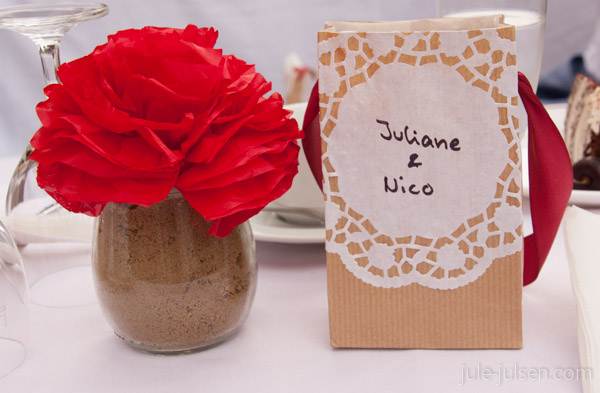 rote Papierblume in Weckglas und selbst gebasteltet Geschenktüte für die Hochzeitsgäste aus Papier