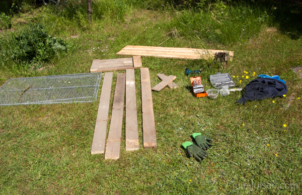 Baumaterial: Holzlatten, Werkzeug, Schrauben und Handschuhe