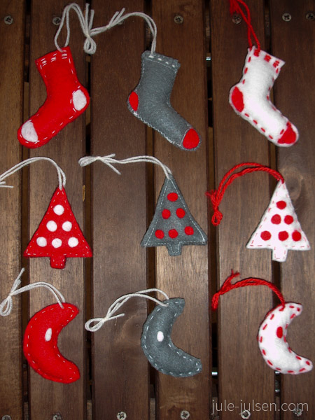 rote, weisse und graue Filzanhaenger in Form von Socken, Weihnachtsbaeumen und Monden