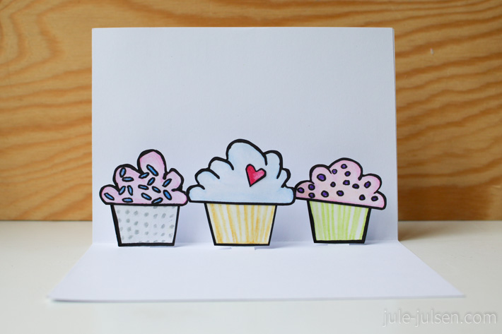 Innenseite der selbstgemachten Geburtstagskarte mit drei bunten Cupcakes, die sich beim Öffnen aufstellen