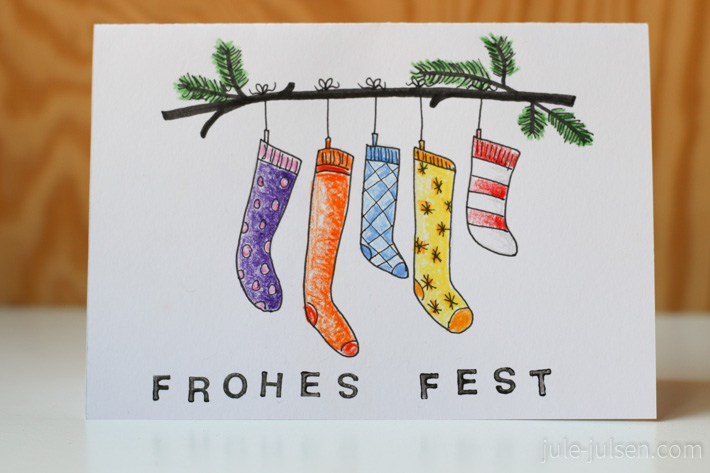gezeichnete Weihnachtskarte mit verschiedenen bunten Socken