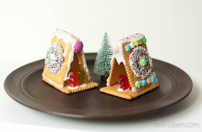 dreieckige Kekshäuser verziert mit bunten Leckereien und Zuckerguss