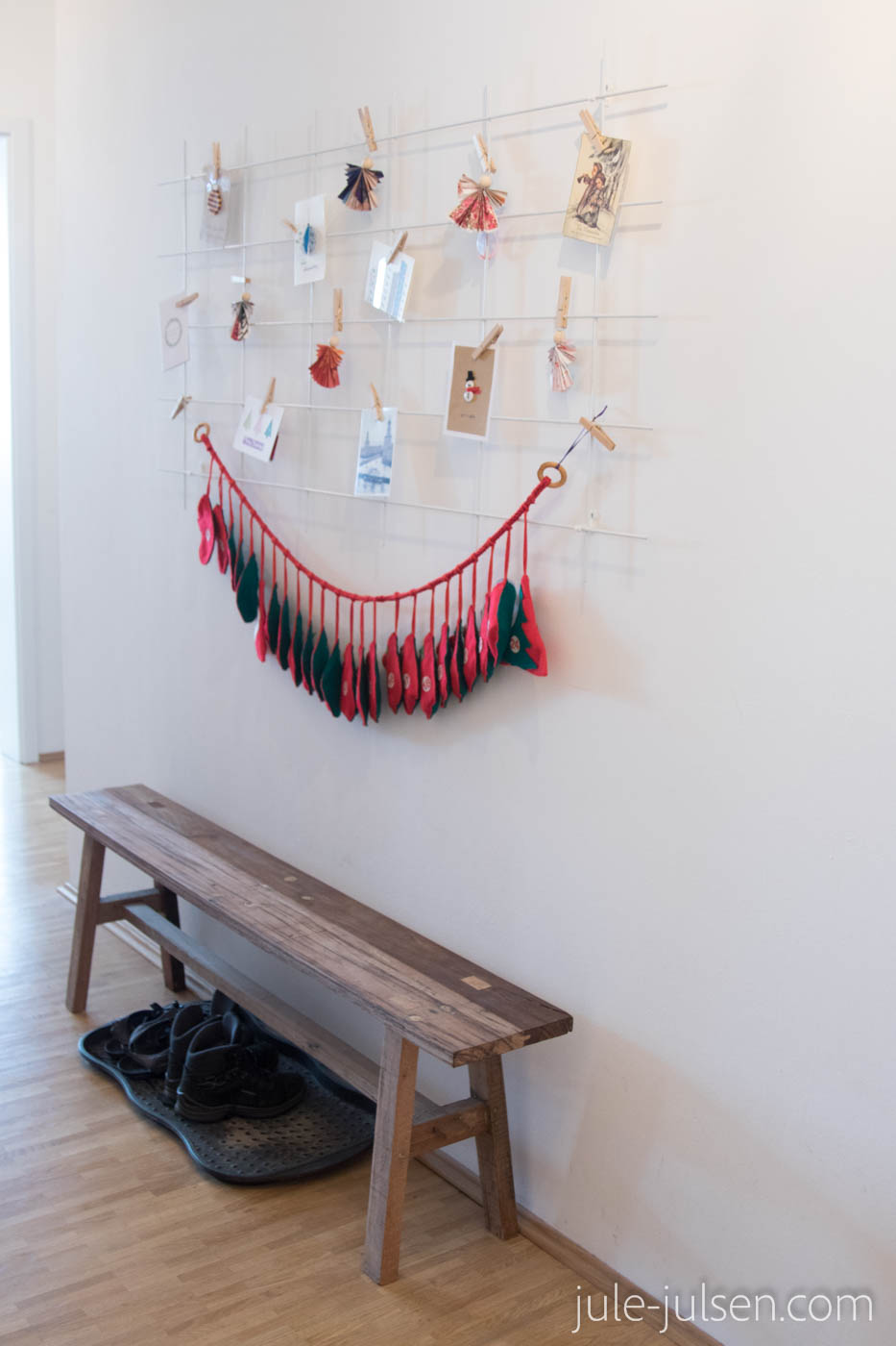 Deko aus selbst gemachten Weihnachtskarten und Papierengeln an einem Pflanzgitter